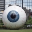 giant eyeball in front of large corporation